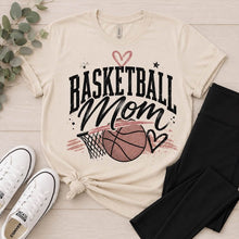 Load image into Gallery viewer, Neutral Basketball Mom crewneck T-shirt featuring a vintage basketball and hoop graphic with black stars and mauve heart accents.
