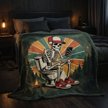 Load image into Gallery viewer, Skeleton on a toilet with a cap and sneakers on a blanket in a bedroom setting