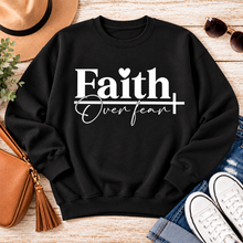 Load image into Gallery viewer, Faith Over Fear Christian inspirational graphic apparel featuring bold white Faith lettering, elegant Over Fear script, a small heart, and a cross design. Available in red and black in short sleeve crewneck, long sleeve crewneck, crewneck sweatshirt, and hoodie styles. Faith-based graphic clothing for women, everyday wear, church outfits, and inspirational gifts.