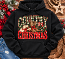 Load image into Gallery viewer, Country Christmas graphic tee with green plaid lettering, red polka dots, cowboy boots, western hat and festive Christmas bows.