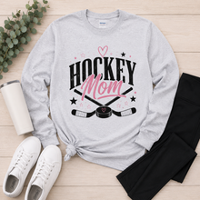 Load image into Gallery viewer, Heather gray long sleeve Hockey Mom graphic tee featuring a black and pink hockey design styled with black leggings and white sneakers.