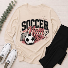Load image into Gallery viewer, Cream crewneck long sleeve Soccer Mom graphic tee featuring pink lettering, soccer ball, goal and leopard print accents.
