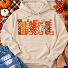 Load image into Gallery viewer, Beige Thankful fall graphic hoodie with orange floral, plaid and polka dot patchwork lettering, styled with jeans and autumn decorations.
