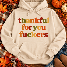 Load image into Gallery viewer, Funny Thankful for You Fuckers Thanksgiving graphic tee featuring bold retro lettering in burnt orange, mustard yellow, olive green, and rust red. Women's fall-inspired short sleeve crewneck shirt available in beige and brown, perfect for Thanksgiving and Friendsgiving.
