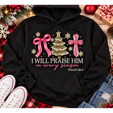 Load image into Gallery viewer, Christian Christmas shirt featuring I Will Praise Him in Every Season Psalm 146:2 graphic with pink bows, decorated Christmas tree, and cream snowflakes.

