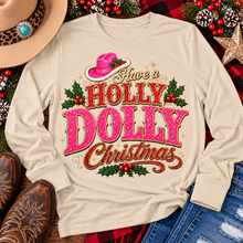 Load image into Gallery viewer, Have a Holly Dolly Christmas western graphic shirt featuring pink and red glitter-inspired lettering, a festive pink cowgirl hat, gold accents, and Christmas holly berries. Available in beige and pink in short sleeve crewneck, V-neck, long sleeve crewneck, and hoodie styles.
