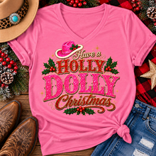 Load image into Gallery viewer, Have a Holly Dolly Christmas western graphic shirt featuring pink and red glitter-inspired lettering, a festive pink cowgirl hat, gold accents, and Christmas holly berries. Available in beige and pink in short sleeve crewneck, V-neck, long sleeve crewneck, and hoodie styles.
