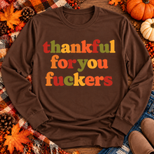 Load image into Gallery viewer, Funny Thankful for You Fuckers Thanksgiving graphic tee featuring bold retro lettering in burnt orange, mustard yellow, olive green, and rust red. Women's fall-inspired short sleeve crewneck shirt available in beige and brown, perfect for Thanksgiving and Friendsgiving.
