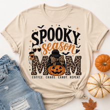 Load image into Gallery viewer, Beige Spooky Season Mom graphic tee featuring leopard print lettering, coffee ghost, jack-o'-lantern pumpkin, bats and Coffee Chaos Candy Repeat text.
