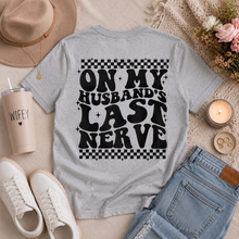 Load image into Gallery viewer, Gray crewneck graphic tee featuring oversized black “On My Husband’s Last Nerve” lettering with retro checkerboard details on the back.
